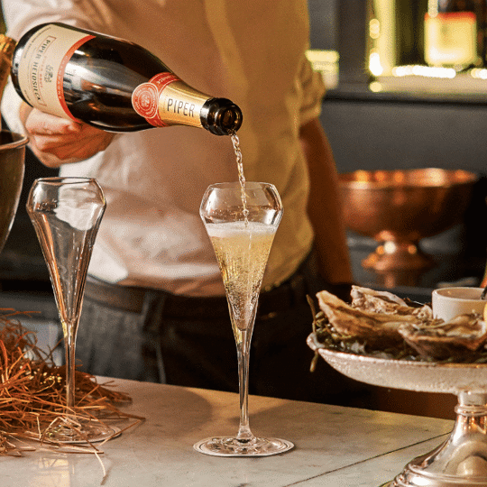 Pouring Piper champagne at Bentley's Oyster Bar & Grill in Mayfair, London